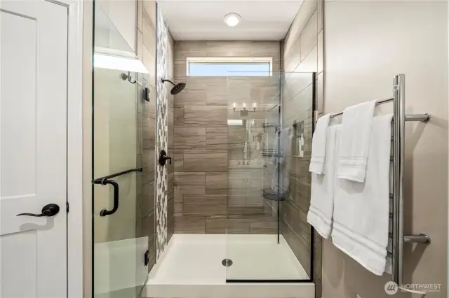 Fully tiled primary shower with  upgraded glass door, oil rubber bronze hardware & a heated towel rack (on a timer!).