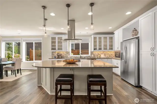 The stunning kitchen with Quartz counters, designer lighting (throughout), full heigh backsplash, 42' cabinetry with etched glass and top tier appliances make this kitchen a joy to entertain in!