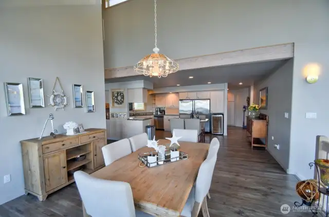 open concept dining and kitchen with vaulted ceilings, rustic beam and modern finishes -perfect for entertaining or everyday coastal living