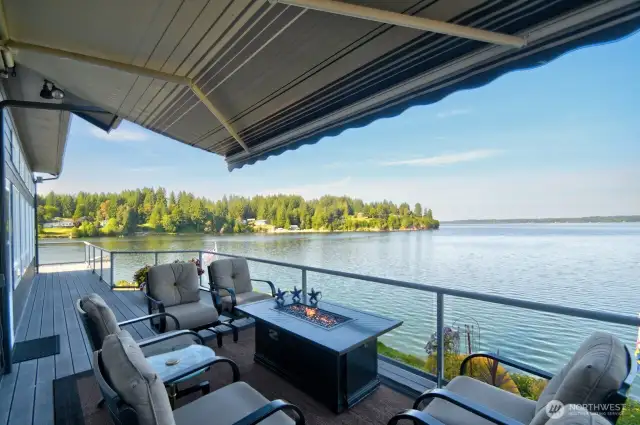 relax under the retractable Sun Setter shade by the propane fire table, soaking in the breathtaking waterfront views and peaceful vibes