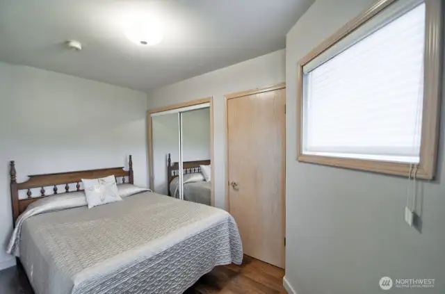 comfortable lower level bedroom with mirrored closet doors and simple charm-perfect for guests or extended stays