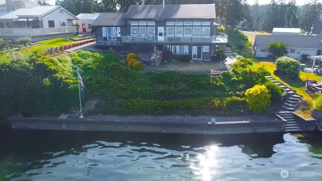stunning waterfront home with wall to wall windows second story composite deck and fully bulk headed shoreline  with private stairs leading to your deeded tidelands for the ultimate PNW living