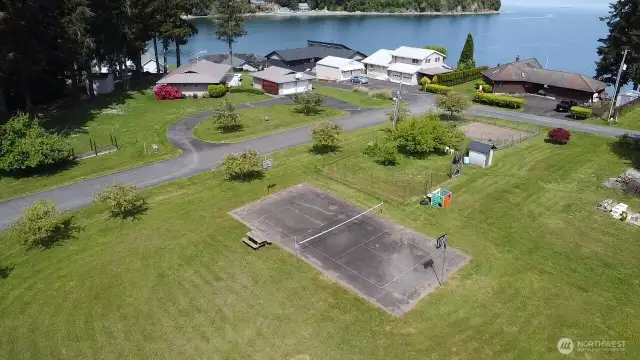 spacious community area with sport court, picnic bench and open green space perfect for play gatherings and recreation