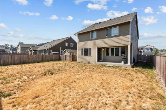 View of the back of the home, dog run on the side and covered patio.