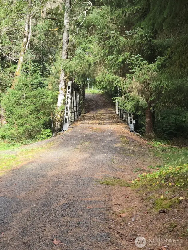 Private gated driveway with bridge over river