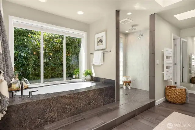 Soaking tub with garden window, step-in shower with glass tile surround.