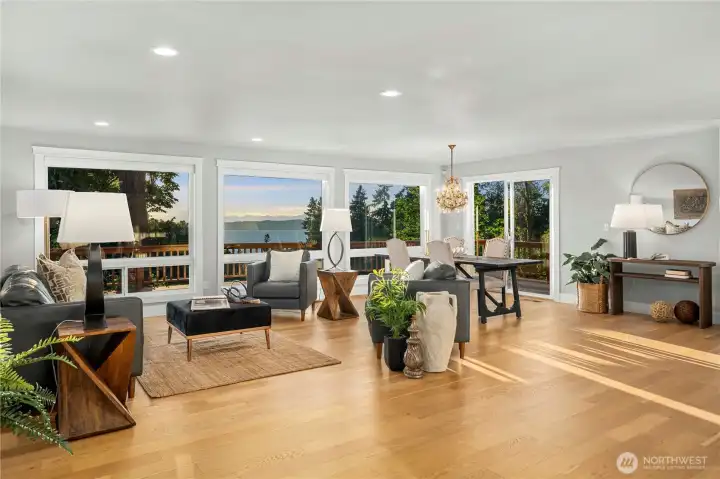open concept living room, family room with fireplace and kitchen with eating bar. Dining room is also pictured here with the chandlier and the slider to the massive deck with inspiring views!