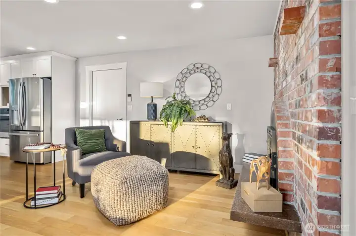 Brick fireplace sitting area just off the kitchen the door here is to the garage.