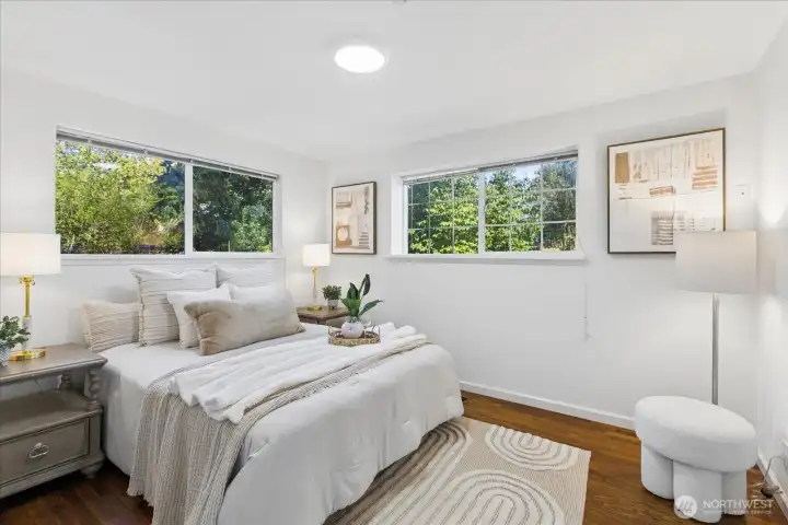 Large primary bedroom features hardwood flooring.