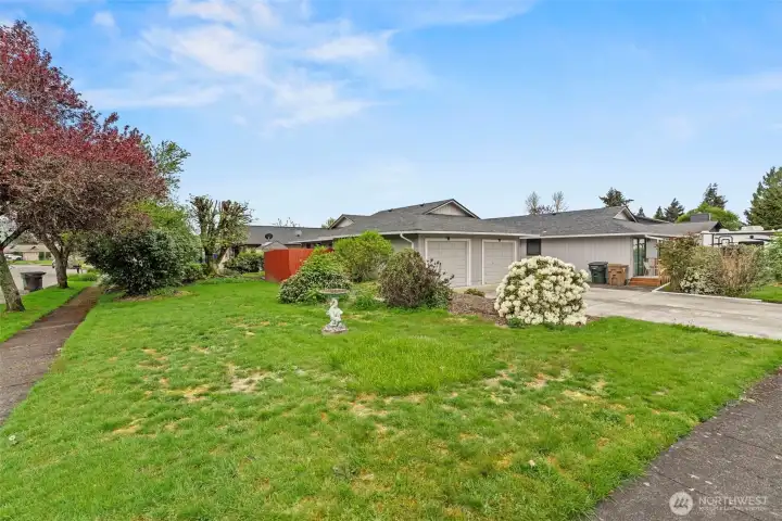 Corner lot with mature landscaping and expanded outdoor space.