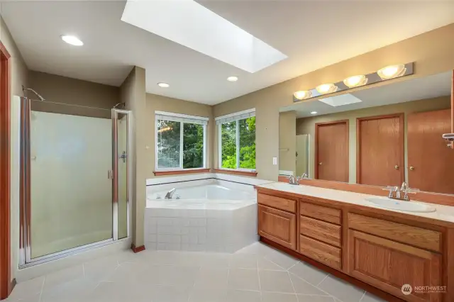 French doors lead to   5-piece bath with tile floors set on a diagonal  Dual sinks with tile counters  Corner soaking tub   Shower with dual shower heads and separate toilet room  Walk in closet