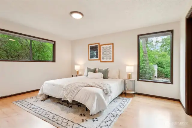 Primary bedroom - main floor - nature and natural light flood this room. Walk in closet and spacious bedroom space.