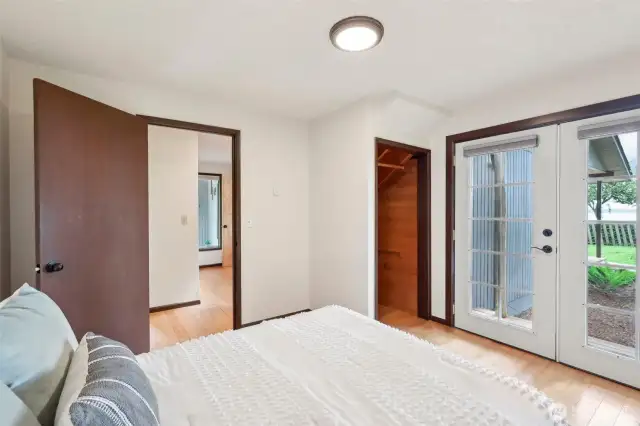 Another view of the second main floor bedroom - deep closet and French doors to a covered patio.