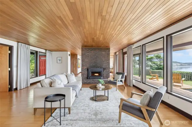 Floor to ceiling windows frame the beautiful views.   Maple floors and wood ceilings in the living room and dining room add warmth and detailing.  Beautiful brick fireplace.