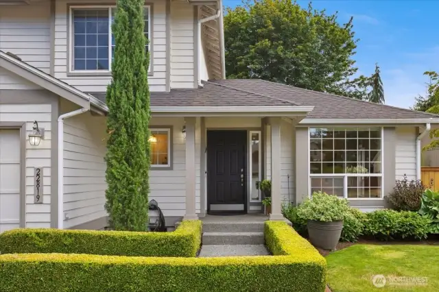 Beautiful boxwood hedges flank the walkway into the entrance.