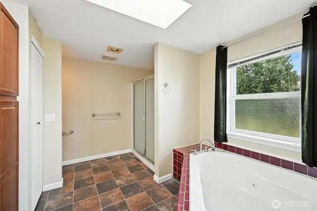 Primary bathroom with large jetted tub and walk-in shower