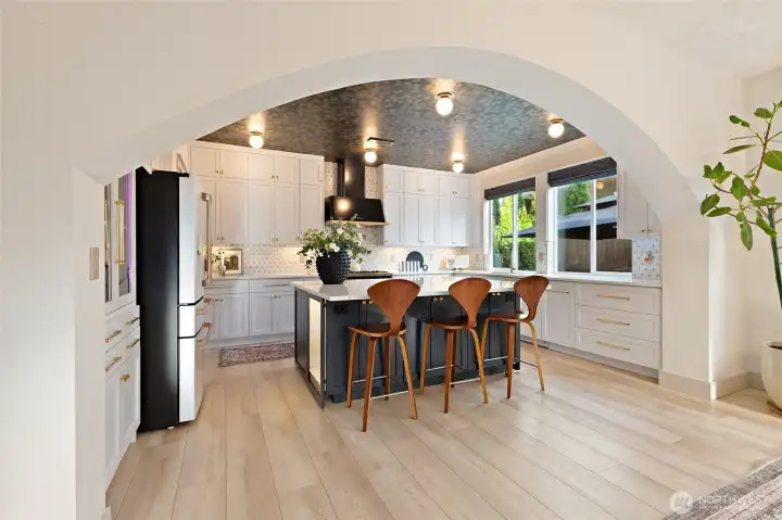 At the heart of the kitchen is an expansive quartz-topped island that effortlessly combines form and function. Designed with storage in mind, it offers cabinetry on all four sides—including elegant glass-front doors that add both style and display potential. Whether you're prepping dinner, entertaining guests, or simply enjoying a casual meal at the bar, this island is as hardworking as it is beautiful.