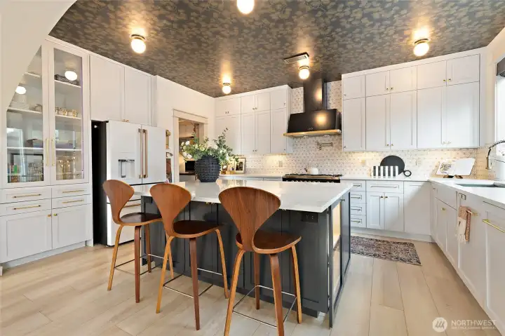 This chef-inspired kitchen blends beauty with functionality at every turn. Custom cabinetry extends to the ceiling for a seamless, elevated look—while maximizing storage. All drawers and cabinets are soft-close, with thoughtful upgrades throughout, including pull-out drawers, a hidden trash/recycle station, and clever hidden compartments. The lower cabinetry is designed for easy access and efficiency. A standout feature: the floor-to-ceiling glass pocket doors with built-in electric plugs, perfect for discreetly storing appliances while keeping counters clear. The matte white 27.8 cu. ft. smart 4-door French door refrigerator includes a versatile convertible drawer—offering flexible storage to match your lifestyle.
