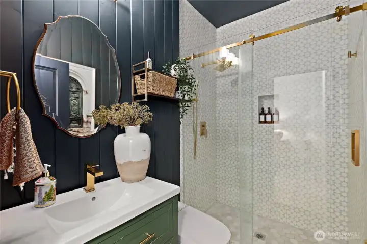 Just steps from the main-level bedroom, this fully remodeled ¾ bathroom feels like a boutique hotel retreat. Elegant vertical shiplap walls are paired with a free-standing vanity and brushed gold fixtures for a modern yet timeless look. The walk-in shower features floor-to-ceiling statement tile and a sleek glass enclosure. A smart toilet adds unexpected luxury with a remote-controlled heated seat, auto flush, and both posterior and feminine wash functions—proof that even the most functional spaces can feel indulgent.