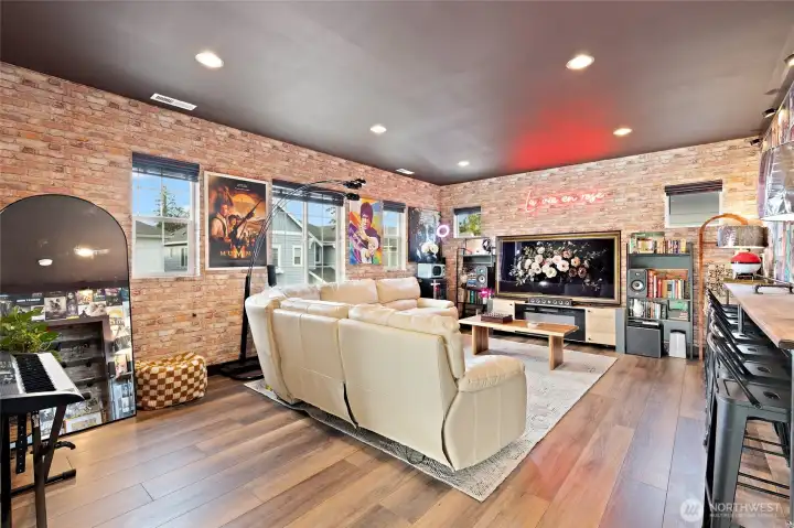 Currently styled as a stunning media and bonus room, this spacious upper-level retreat is officially listed as the home’s fifth bedroom. High-end custom wallpaper wraps the entire room, setting a moody, cinematic tone perfect for movie nights, entertaining, or unwinding in style. Rich, dark LVP flooring enhances the ambiance and ties the space together beautifully. Whether you envision a guest suite, game room, or private lounge, this versatile space is ready to flex with your lifestyle.