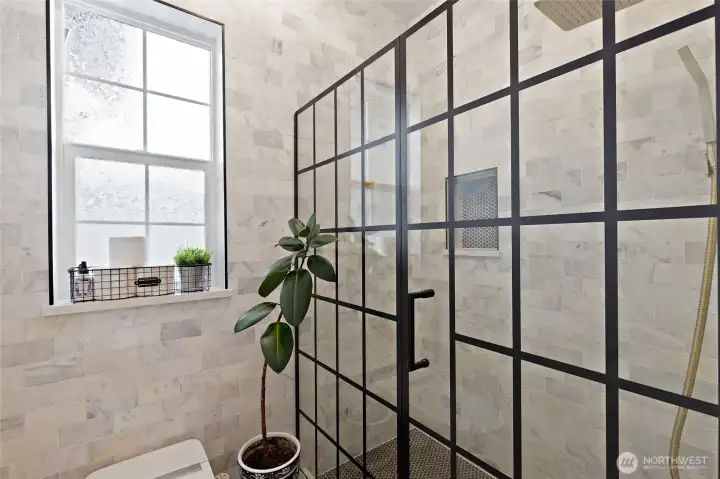Step into spa-inspired luxury in this beautifully tiled shower, complete with floor-to-ceiling marble tile and a striking black-framed glass enclosure that adds modern edge. The smart toilet offers elevated comfort with a remote-controlled system featuring heated seating, auto flush, and both posterior and feminine wash options. Every element is thoughtfully curated for both style and function.