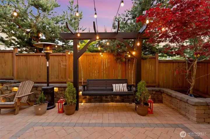 This backyard oasis has been thoughtfully upgraded for both beauty and function. Pavers extend gracefully on all three sides, accented by integrated paver and cap lights for a warm evening glow. A pergola with a charming swing (included!) anchors the space, framed by a stunning Japanese maple, flowering plum trees, and mature evergreens for year-round color and privacy. Raised stone planters double as seating areas, creating a perfect setting for relaxing, entertaining, or simply soaking in the peaceful ambiance.