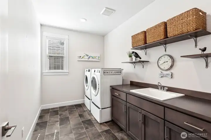 Large laundry room with shelving and 76" counter and deep laundry sink.