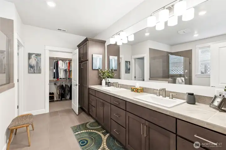 Double vanity offers additional cabinets and storage.  Also the large wall to wall mirror adds depth and brightness to the space.  Walk in closet is adjacent and convenient to the bathroom.