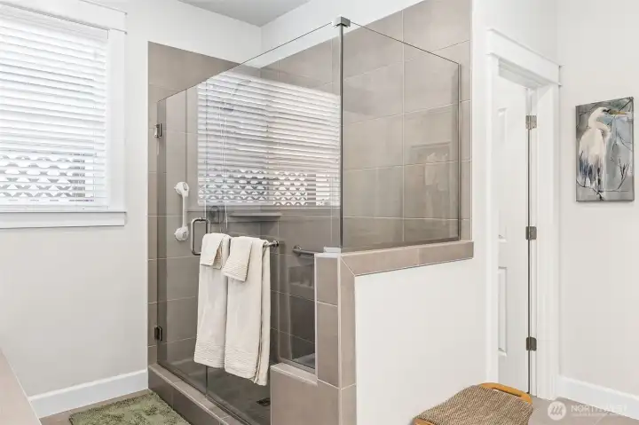 Shower in primary bath has a bench and grab bars