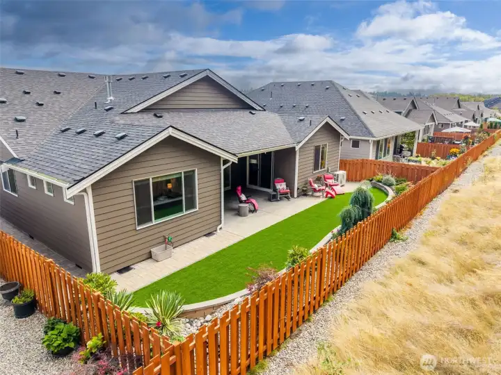 Fully fenced back yard with turf, Covered patio, paved walkways, planters and garden areas.