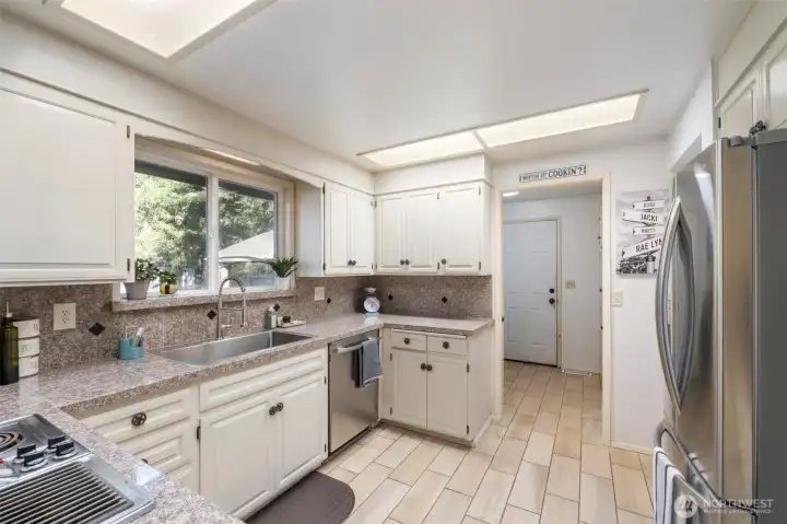 Beyond the kitchen find the laundry/utility room with additional pantry storage.