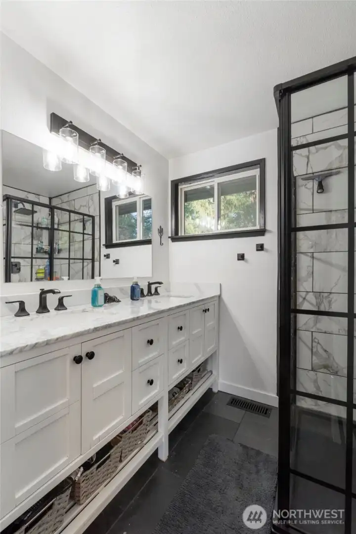 Gorgeous updated En-suite bathroom offers dual vanities and a stylish glass shower.
