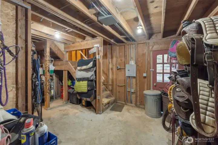 Large tack room located at the end of the isle way offers lots of space. A stairwell leads up to the hayloft as well as a heated room for an office or additional storage.