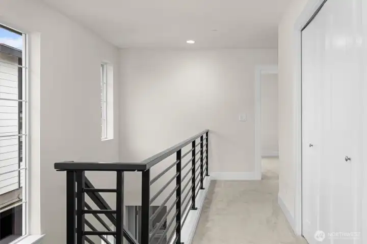 The staircase leads gracefully up to the bedrooms, creating a natural separation between living spaces and private areas.