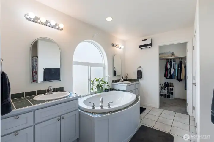 Deep jetted tub for a spa like experience and separate vanities. Wal in closet is accessed through here as well.