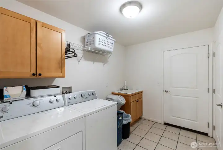 Good sized laundry room with utility sink, and additional storage room, step right into the garage through here as well.