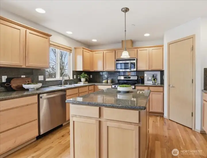 Chef's kitchen featuring large island, walk-in pantry, and stainless steel appliances.  New dishwasher in 2026.