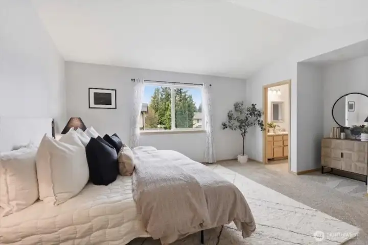 Vaulted ceilings in the primary bedroom featuring his & hers closets.