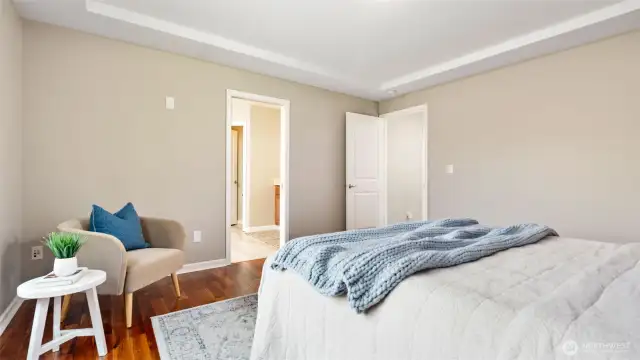The tray ceiling adds just the right touch of architectural interest, giving the primary suite a feeling of quiet sophistication. Just beyond, the doorway leads into the ensuite - your own private escape, ready for relaxation and comfort