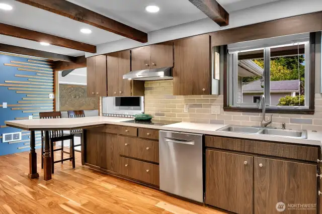 Functional and inviting kitchen with flat cooktop, plenty of counter space, and a large window bringing in natural light.