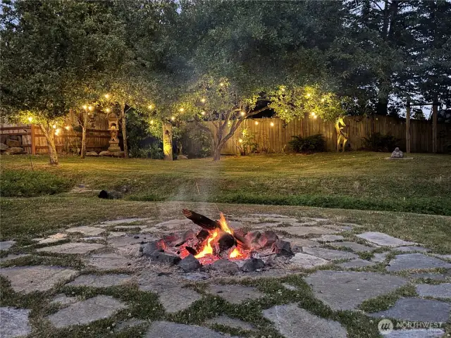 Relax under the lights by the fire in this peaceful backyard setting.