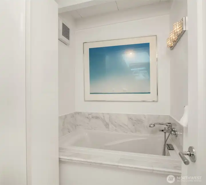 The primary bathroom features a luxurious soaking tub