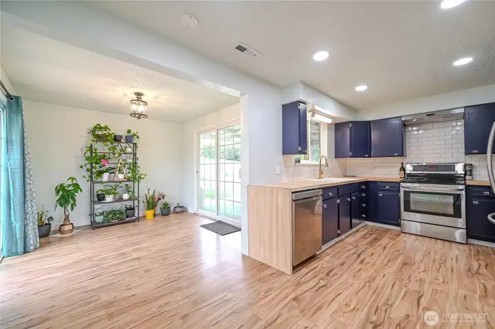 Open concept updated kitchen and dining rooms with hard flooring surfaces,new stainless steel appliances and tile backsplash to enjoy