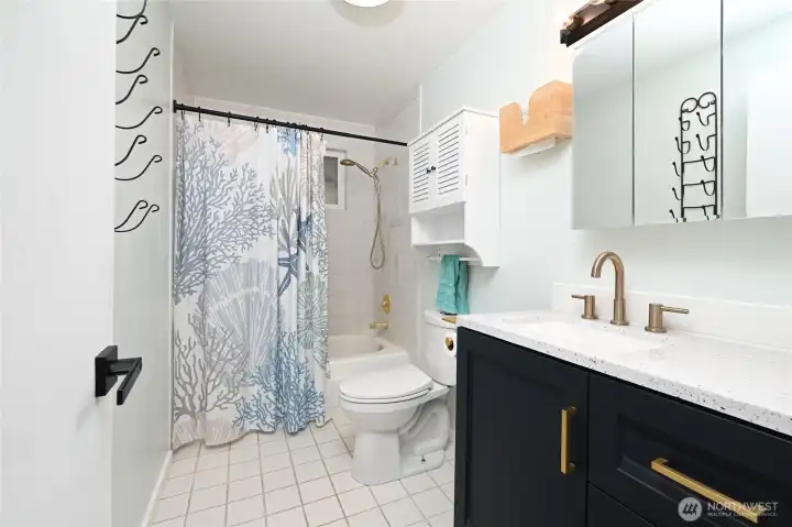 Nicely updated main bathroom with tile flooring and quartz counters