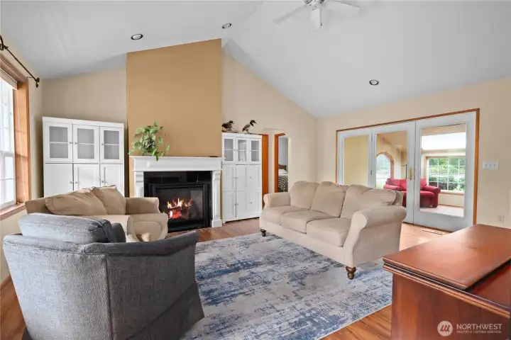 The spacious, main living area with vaulted ceilings. French doors lead to the large sun/family room. New propane fireplace