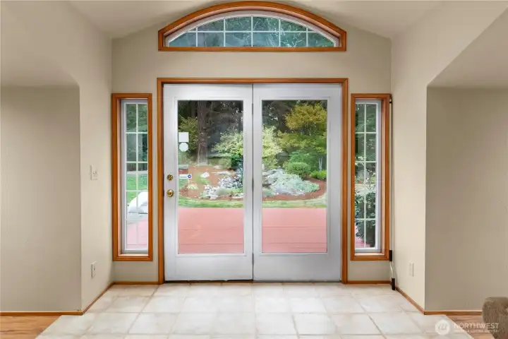 Tiled flooring and French doors leading to the sun drenched back deck and beautiful waterfall feature.