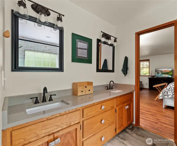 Completely remodeled en-suite, with solid surface countertops, dual sink vanity, tiled flooring and solid wood cabinets.