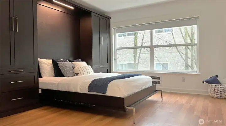 A closer look at the Queen sized bed featuring lighting, cabinets, and drawers.