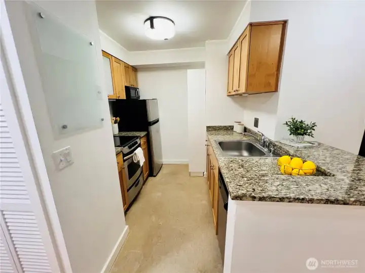 Don't miss the microwave above the fridge and open shelving for additional storage space.