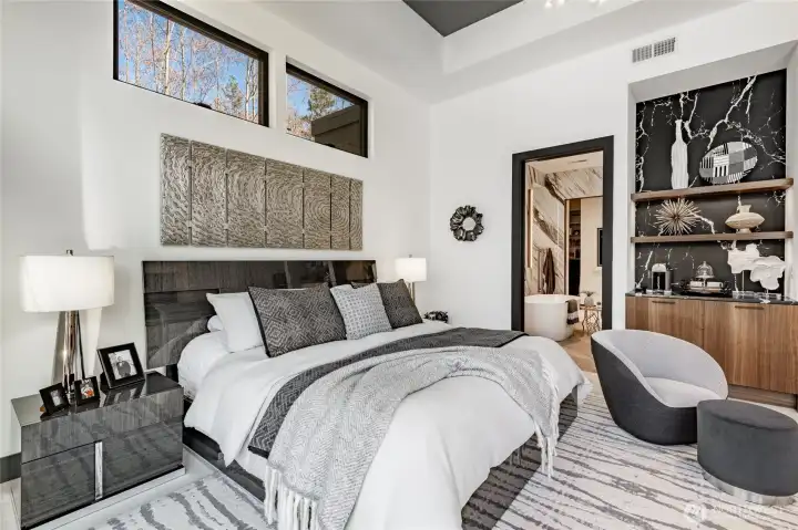 Primary bedroom looking into the bathroom suite. Black-out blinds on all windows. Wet bar to the right of the bathroom.